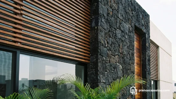 Detalle de fachada moderna en piedra y madera para Casa pequeña Mía planos 1 piso con ventanales.