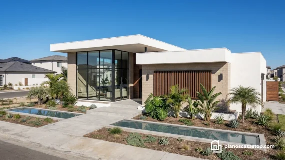 Fachada de planos de casa de 1 piso Porta moderna con ventanales de doble altura, piedra clara y paisajismo tropical.