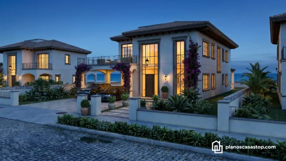 Fachada iluminada de los planos de casa colonial jazmín con ventanales altos, techos de teja y jardín tropical al anochecer.