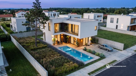 Fachada moderna con piscina inspirada en los planos de casa de 2 pisos CBAM durante el atardecer.