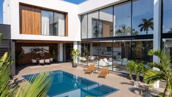 Fachada y piscina según los Planos de casa moderna Olmo con ventanales de doble altura y acabados en madera.