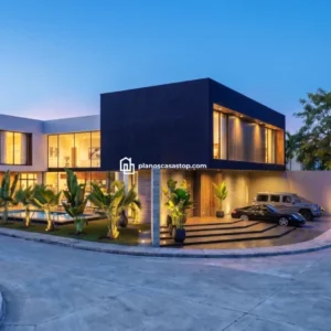 Fachada nocturna de lujosa vivienda según los planos de casa moderna Olmo con piscina y volúmenes oscuros minimalistas.