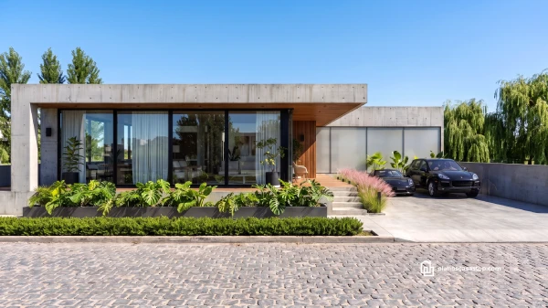 Fachada de Casa Flora diseño moderno 20x20 con concreto visto, ventanales de piso a techo y jardín frontal tropical.